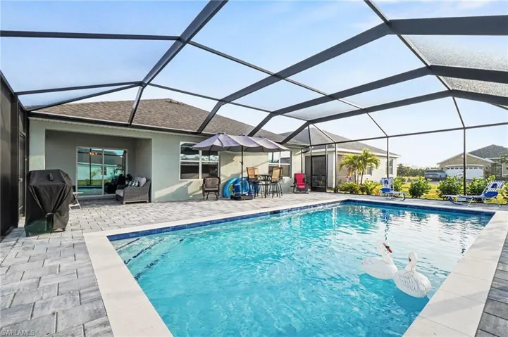 Swimming pool featuring a sunroom, a grill, a lanai, and a patio