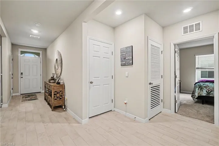 Foyer entrance with light wood finished floors and recessed lighting