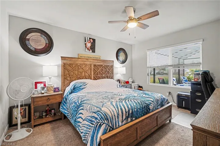 Carpeted bedroom with a ceiling fan