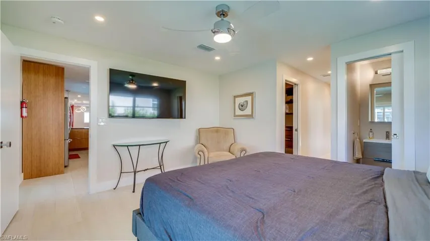 Bedroom featuring recessed lighting, ceiling fan, connected bathroom, and freestanding refrigerator