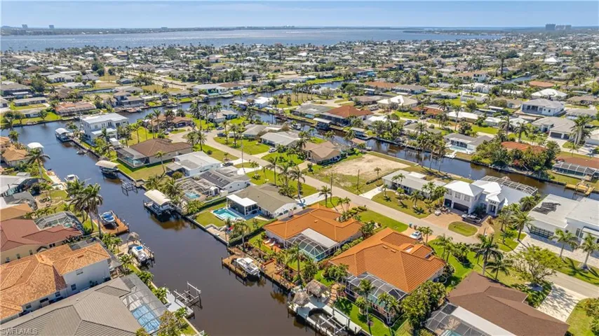 Aerial view of property's location featuring a nearby body of water and nearby suburban area