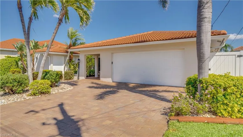 Mediterranean / spanish house featuring stucco siding, a garage, decorative driveway, and a tiled roof