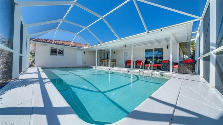 Outdoor pool featuring a lanai, a sunroom, and a patio area