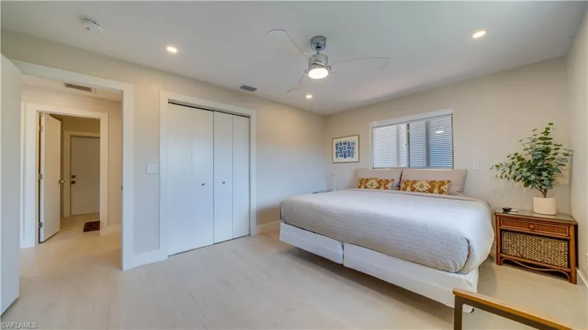 Bedroom with light wood-style floors, a ceiling fan, recessed lighting, and a closet