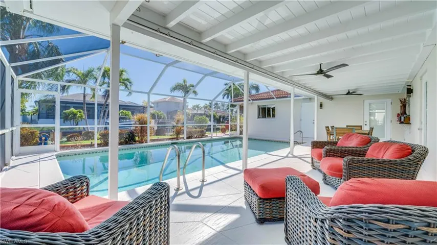 Outdoor pool with a sunroom, a patio area, a lanai, and outdoor furniture