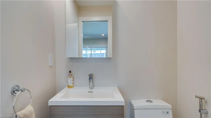 Half bathroom featuring vanity and toilet