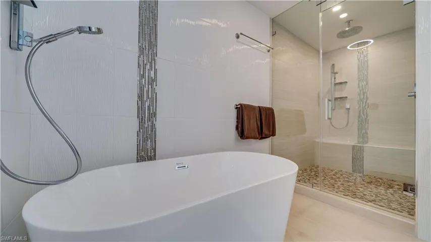 Full bathroom with a shower stall and a soaking tub