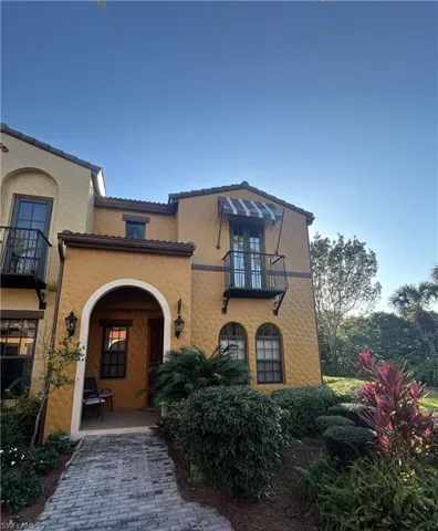 View of front of home featuring a balcony and stucco siding
