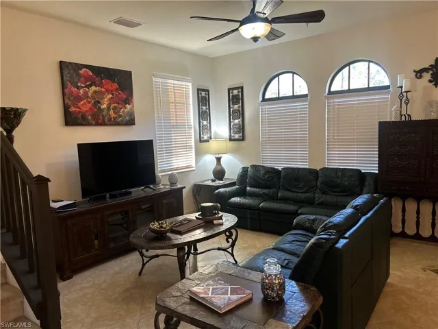 Living room featuring a ceiling fan and light tile patterned flooring