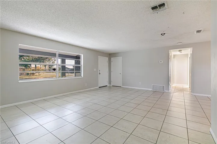 Spare room featuring a textured ceiling and light tile patterned floors
