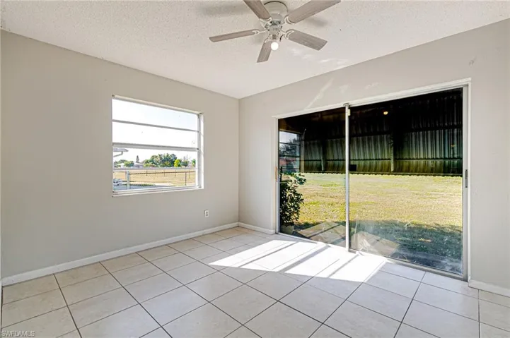 Spare room with a textured ceiling, light tile patterned flooring, and ceiling fan