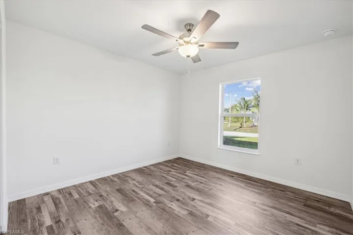 Unfurnished room with ceiling fan and hardwood / wood-style flooring
