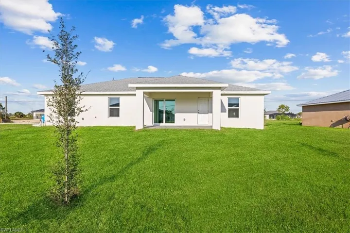 Rear view of house featuring a yard