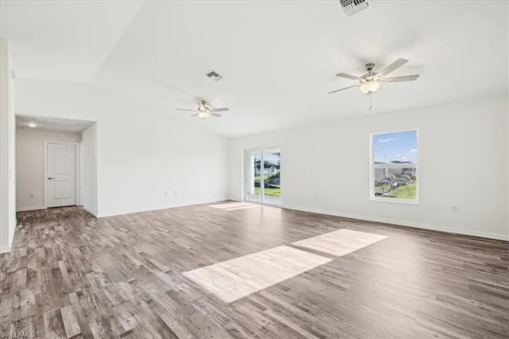 Empty room featuring a wealth of natural light and hardwood / wood-style flooring
