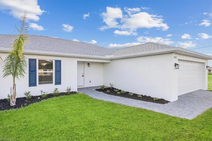 Ranch-style house featuring a front yard and a garage