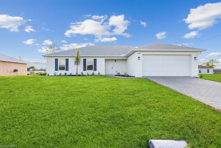 Ranch-style house featuring a front lawn and a garage