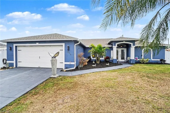 Ranch-style house with stucco siding, a front yard, driveway, an attached garage, and a shingled roof
