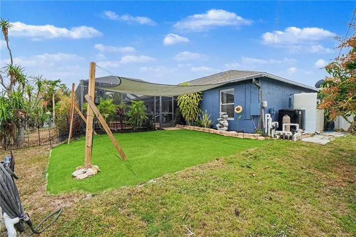 Back of property featuring a sunroom, a lanai, stucco siding, and a playground