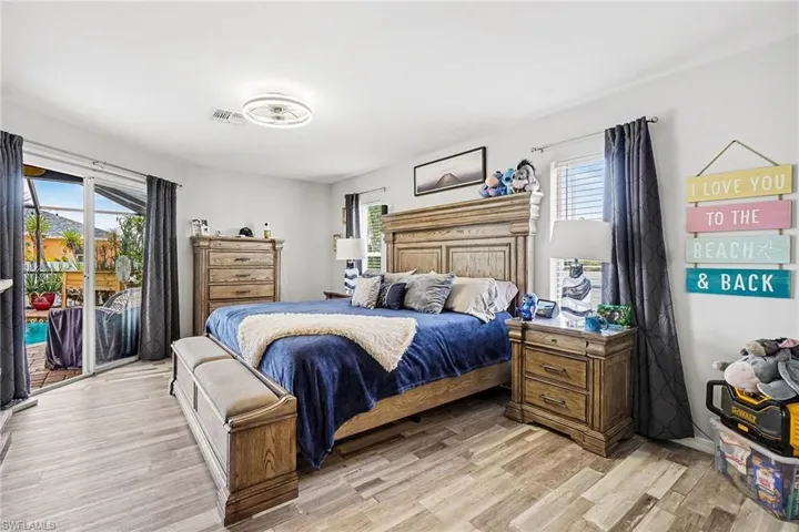 Bedroom with access to exterior, multiple windows, and light wood-style flooring