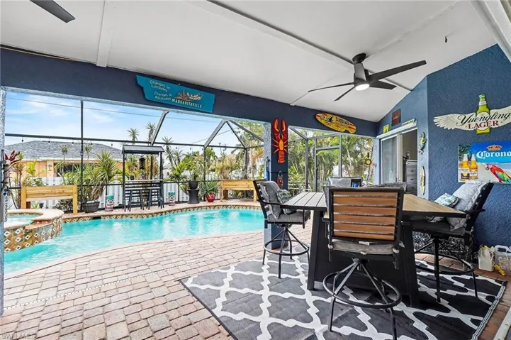 View of swimming pool with a lanai, a pool with connected hot tub, a patio area, and a sunroom
