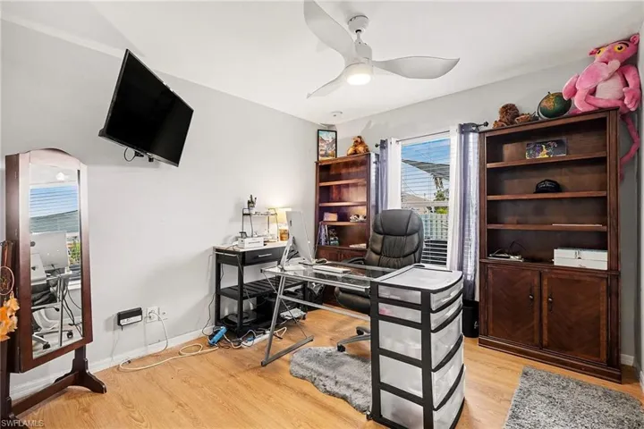 Office space with light wood-type flooring and ceiling fan