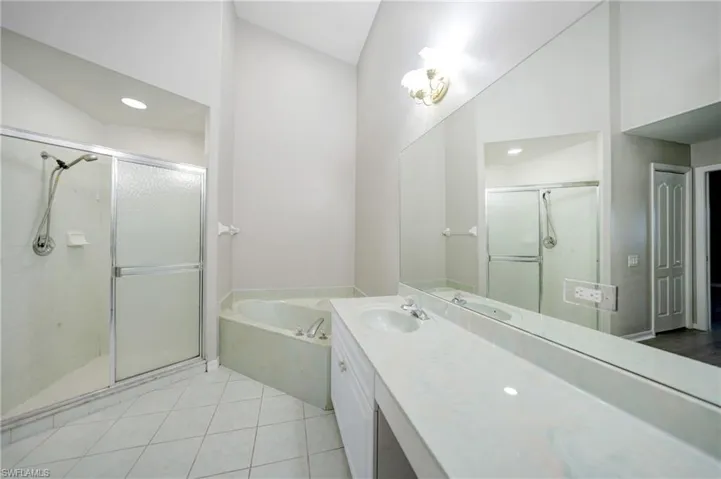 Bathroom with tile flooring, independent shower and bath, and large vanity