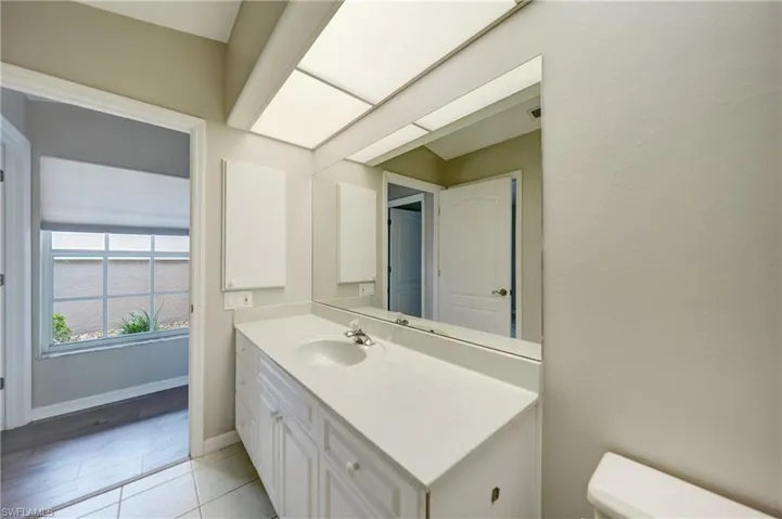 Bathroom featuring tile floors, vanity with extensive cabinet space, and toilet