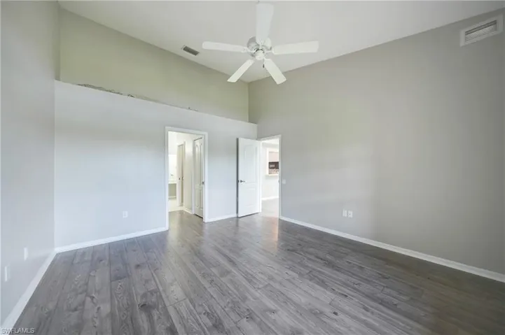 Spare room featuring high vaulted ceiling, hardwood / wood-style floors, and ceiling fan
