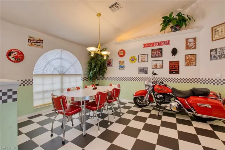 Dining area featuring tile patterned floors and vaulted ceiling