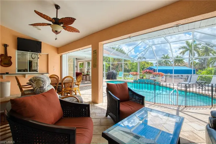 View of patio / terrace with a sunroom, ceiling fan, an outdoor pool, glass enclosure, and a grill