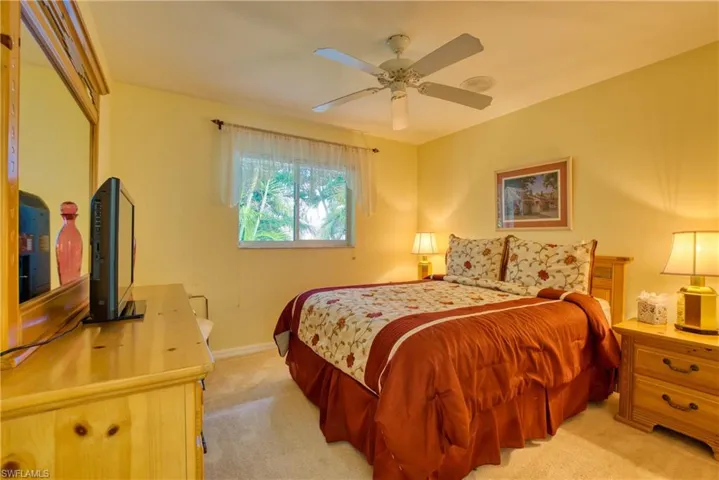 Bedroom with light colored carpet and ceiling fan