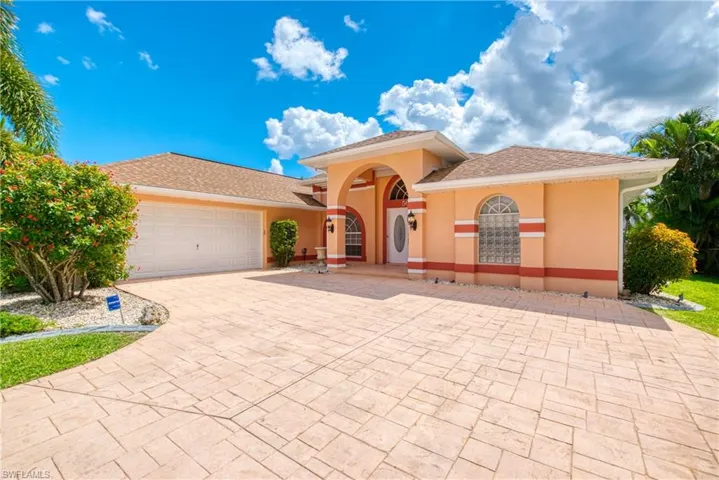 Mediterranean / spanish house with decorative driveway, an attached garage, stucco siding, and a shingled roof