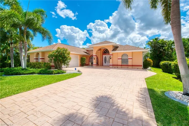 Mediterranean / spanish-style home with decorative driveway, a front yard, a garage, and stucco siding