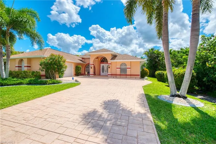 Mediterranean / spanish-style house featuring decorative driveway, a front lawn, stucco siding, and an attached garage