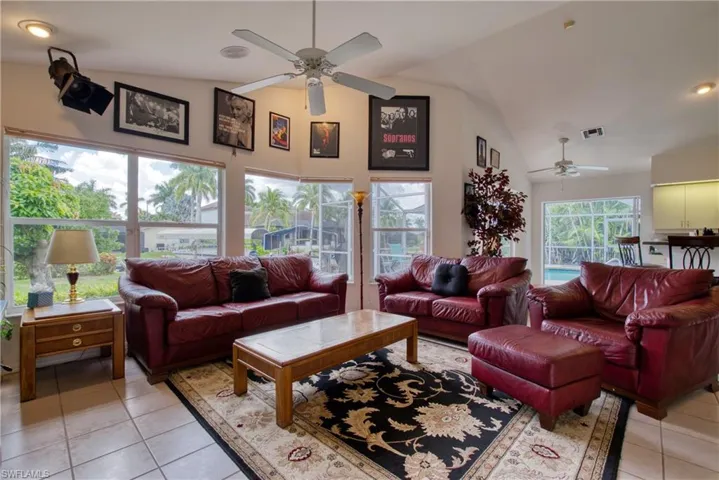 Living area featuring vaulted ceiling, light tile patterned floors, a ceiling fan, and recessed lighting