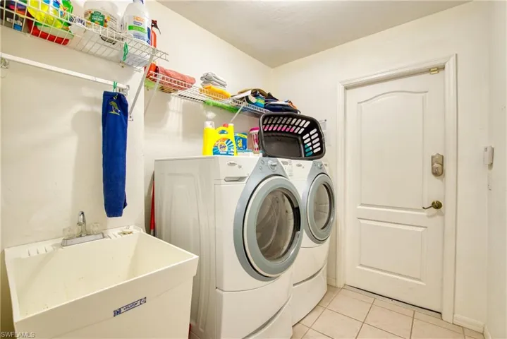 Washroom featuring washer and dryer and light tile patterned floors