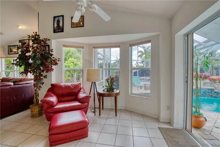Sitting room featuring vaulted ceiling, plenty of natural light, a ceiling fan, and light tile patterned floors