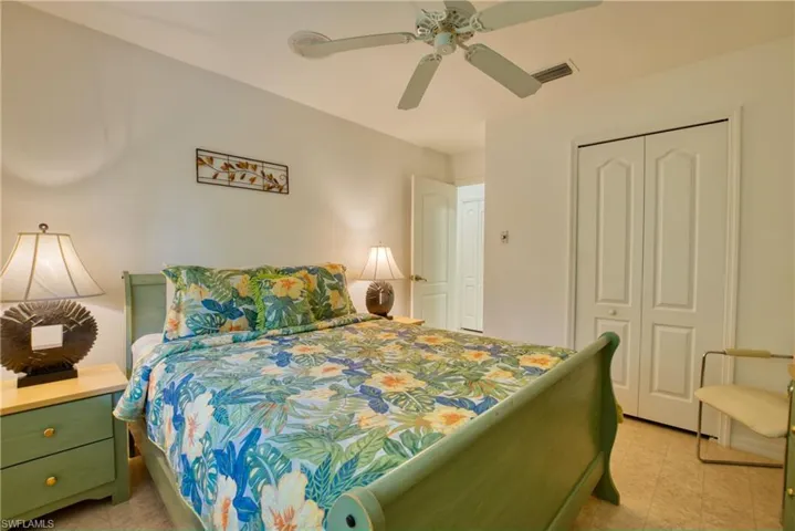 Bedroom with a closet, ceiling fan, and light floors