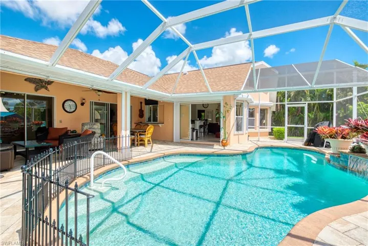 Swimming pool featuring a patio, glass enclosure, and a sunroom