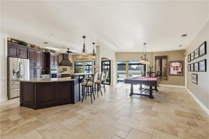 Light, bright and open kitchen with breakfast bar, stainless steel appliances, pendant lighting, Travertine floors, quartz counter tops.