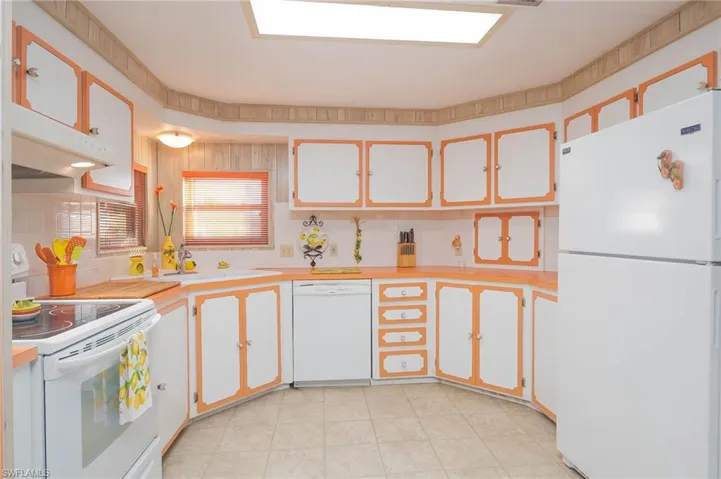 Kitchen featuring tasteful backsplash, white cabinetry, sink, and white appliances