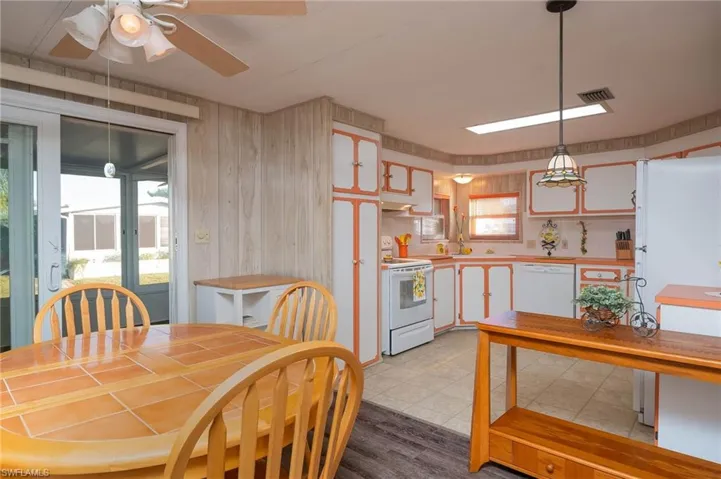 Dining room featuring light hardwood / wood-style flooring, plenty of natural light, wooden walls, and ceiling fan