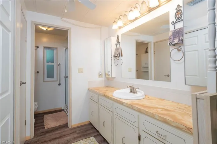 Bathroom featuring hardwood / wood-style flooring, vanity, toilet, and walk in shower