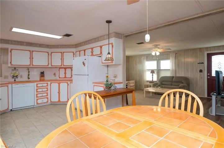 Dining room with ceiling fan and wood walls