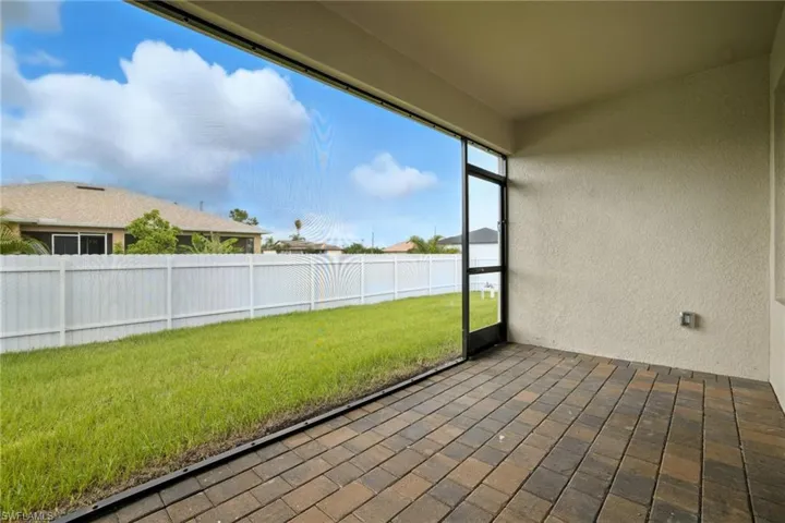 Screened patio featuring multi-toned paver flooring and textured stucco walls
