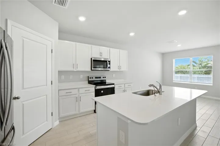 Contemporary kitchen featuring a large central island with an undermount sink and gooseneck faucet