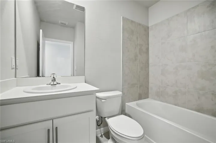 Contemporary full bathroom featuring a white vanity with integrated sink, coordinating countertop, and chrome faucet