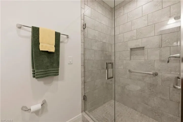 Bathroom featuring a stall shower and baseboards
