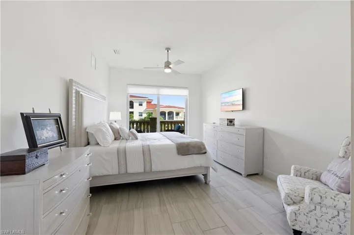 Bedroom featuring access to outside, wood finish floors, and a ceiling fan