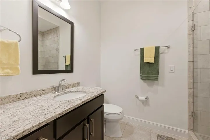 Full bathroom featuring vanity, a shower stall, and light tile patterned flooring
